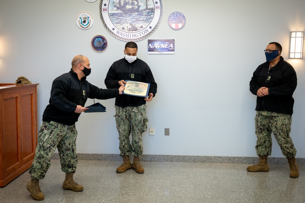 Master-at-Arms 1st Class Damon Harris reenlists in the United States Navy