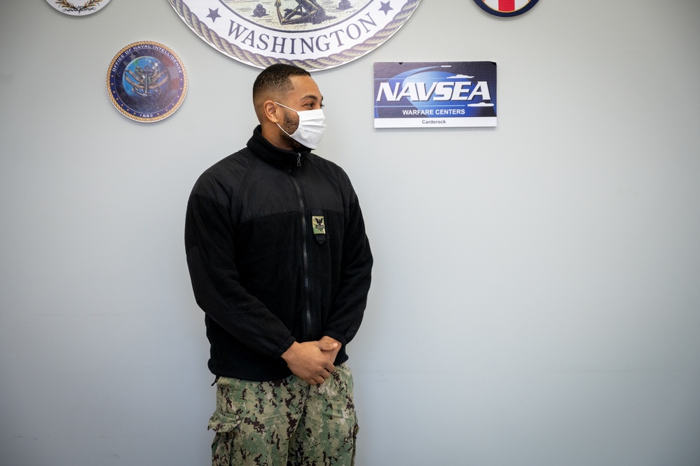 Master-at-Arms 1st Class Damon Harris reenlists in the United States Navy