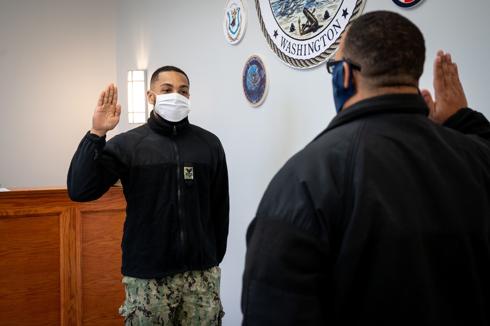 Master-at-Arms 1st Class Damon Harris reenlists in the United States Navy