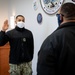 Master-at-Arms 1st Class Damon Harris reenlists in the United States Navy