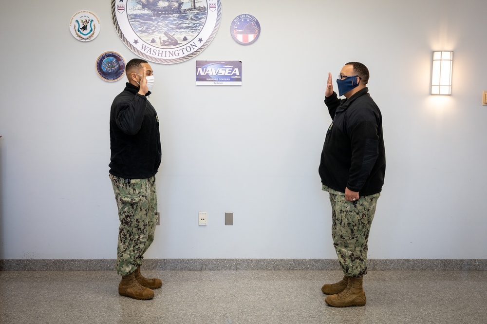 Master-at-Arms 1st Class Damon Harris reenlists in the United States Navy