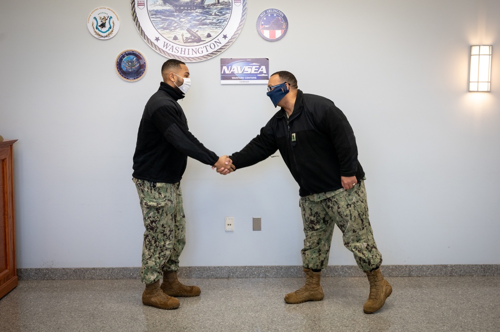 Master-at-Arms 1st Class Damon Harris reenlists in the United States Navy