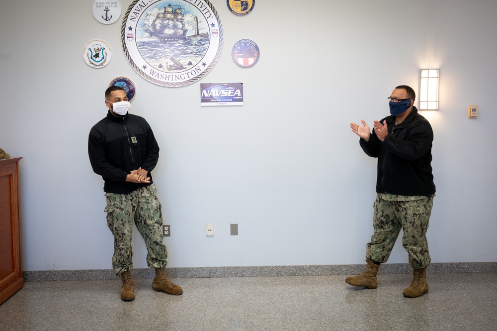 Master-at-Arms 1st Class Damon Harris reenlists in the United States Navy