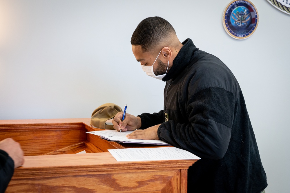 Master-at-Arms 1st Class Damon Harris reenlists in the United States Navy