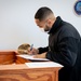 Master-at-Arms 1st Class Damon Harris reenlists in the United States Navy