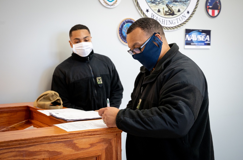 Master-at-Arms 1st Class Damon Harris reenlists in the United States Navy