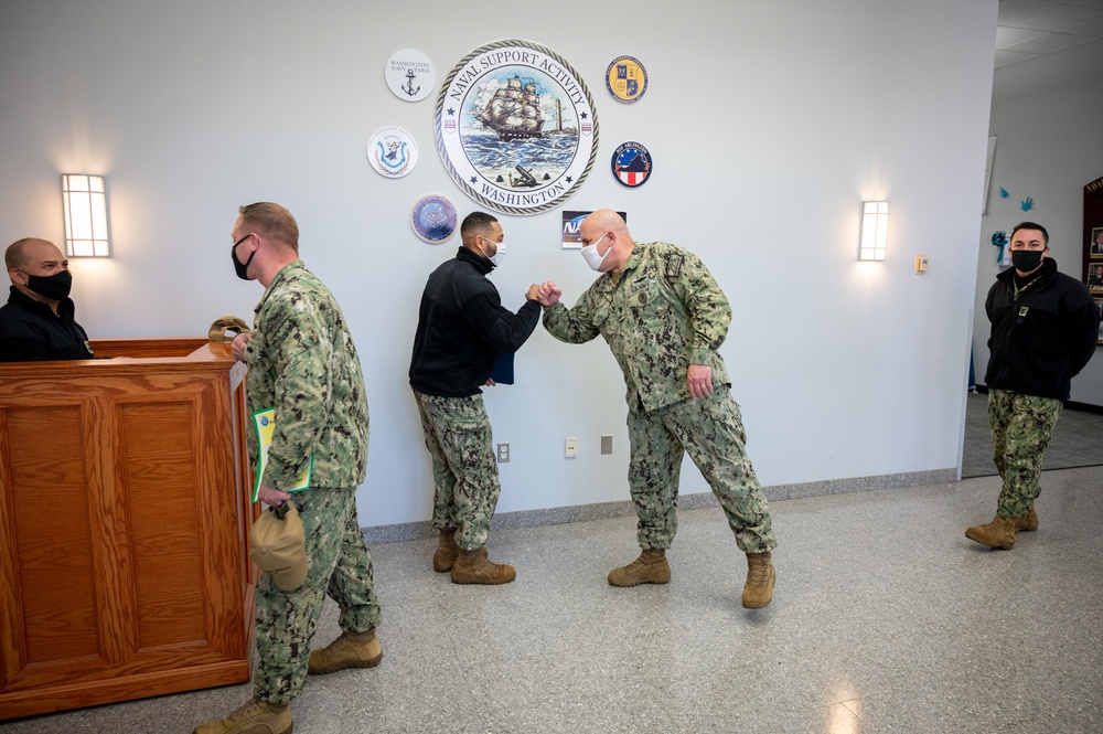 Master-at-Arms 1st Class Damon Harris reenlists in the United States Navy