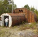 Community member peers into an abandoned former military structure