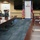 A formal bilateral meeting is taking place at USAID headquarters, indicated by the prominent USAID banner and the presence of both an American flag and a British Union Jack flag. Participants are seated on opposite sides of a large conference table, with most wearing face masks suggesting this occurred during the COVID-19 pandemic period. The setting appears to be an official diplomatic or aid coordination meeting between US and UK representatives.