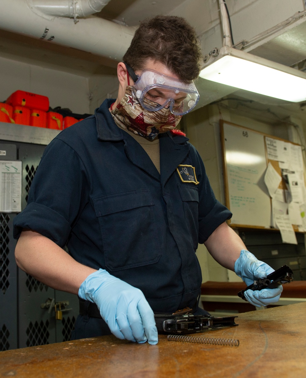 A Sailor Disassembles a Firearm