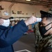 U.S. Sailor medically screens another Sailor