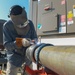 Shipyard worker welds pipe