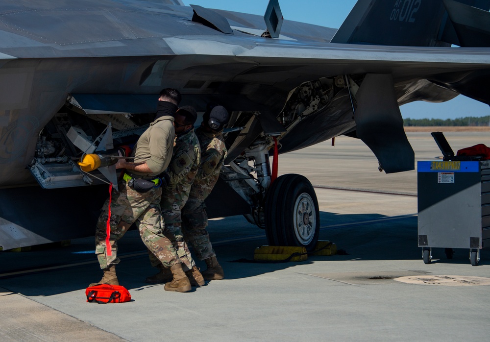 Team Tyndall Airmen load AIM-9 missiles on F-22s