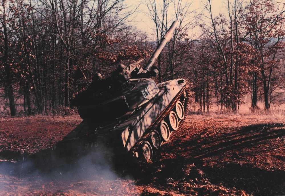 Tank speedly driving up enbankment at late 1980's JRTC at Fort Chaffee, AR