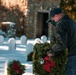 A volunteer laying a wreath