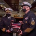 Command Master Chief Marc Puco (right), presents Capt. Randy Peck, commanding officer of the aircraft carrier USS John C. Stennis (CVN 74), with his commissioning pennant, during a change of command ceremony