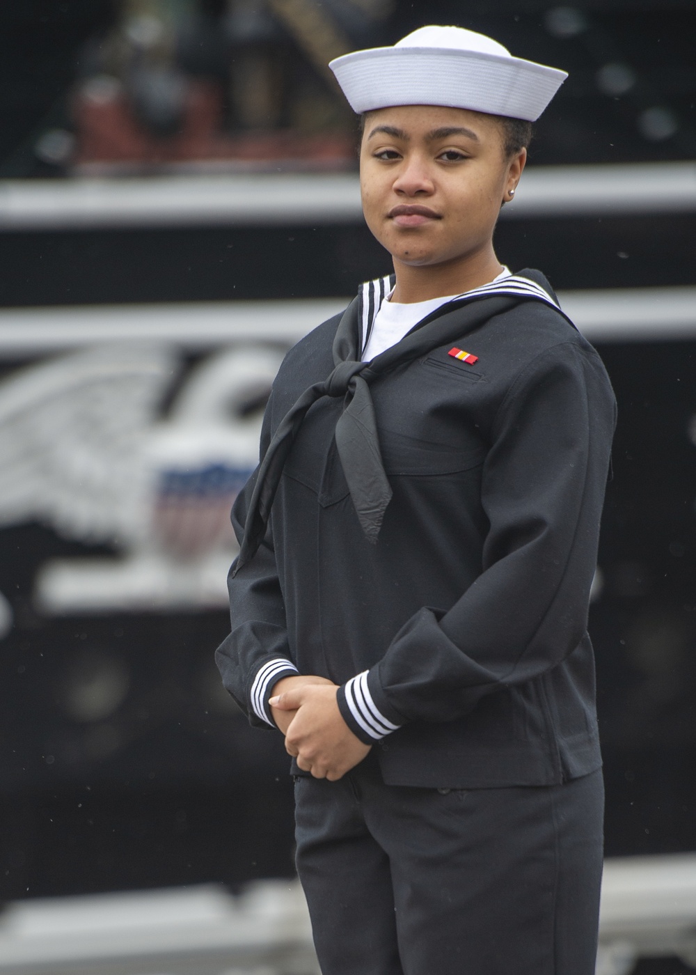 Seaman Jordan Sharp poses for a photo in front of USS Constitution
