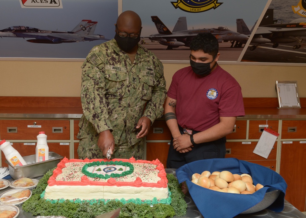 Sailors cut cake.