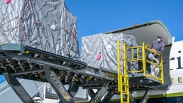 Aircraft carrying supplies for emergency field hospital lands at Plant 42