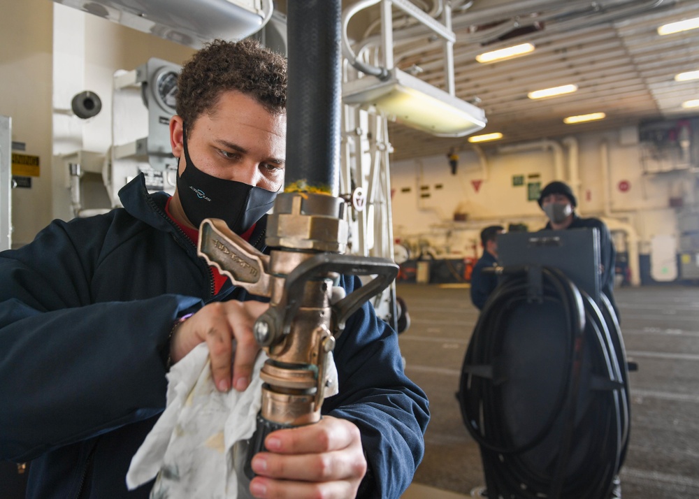 USS America (LHA 6)'s Sailor polishes aqueous film forming foam hose.