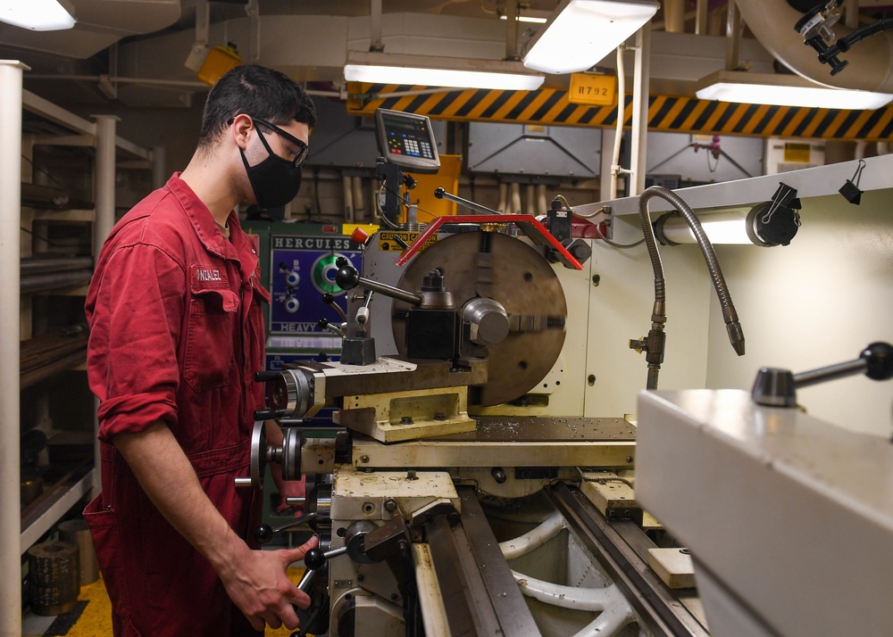 USS America (LHA 6)'s Sailor cuts bolt.