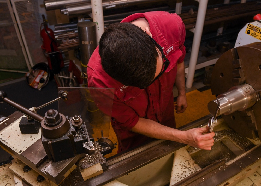 USS America (LHA 6)'s Sailor measures bolt.