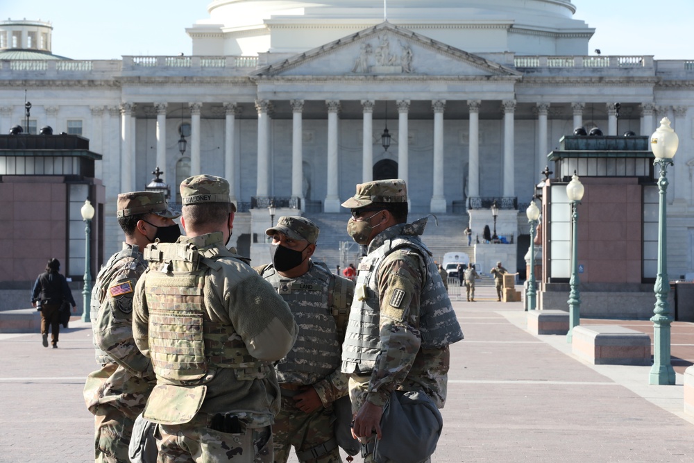 Soldiers with 1173rd Transportation Company discuss the next steps for their security shift.