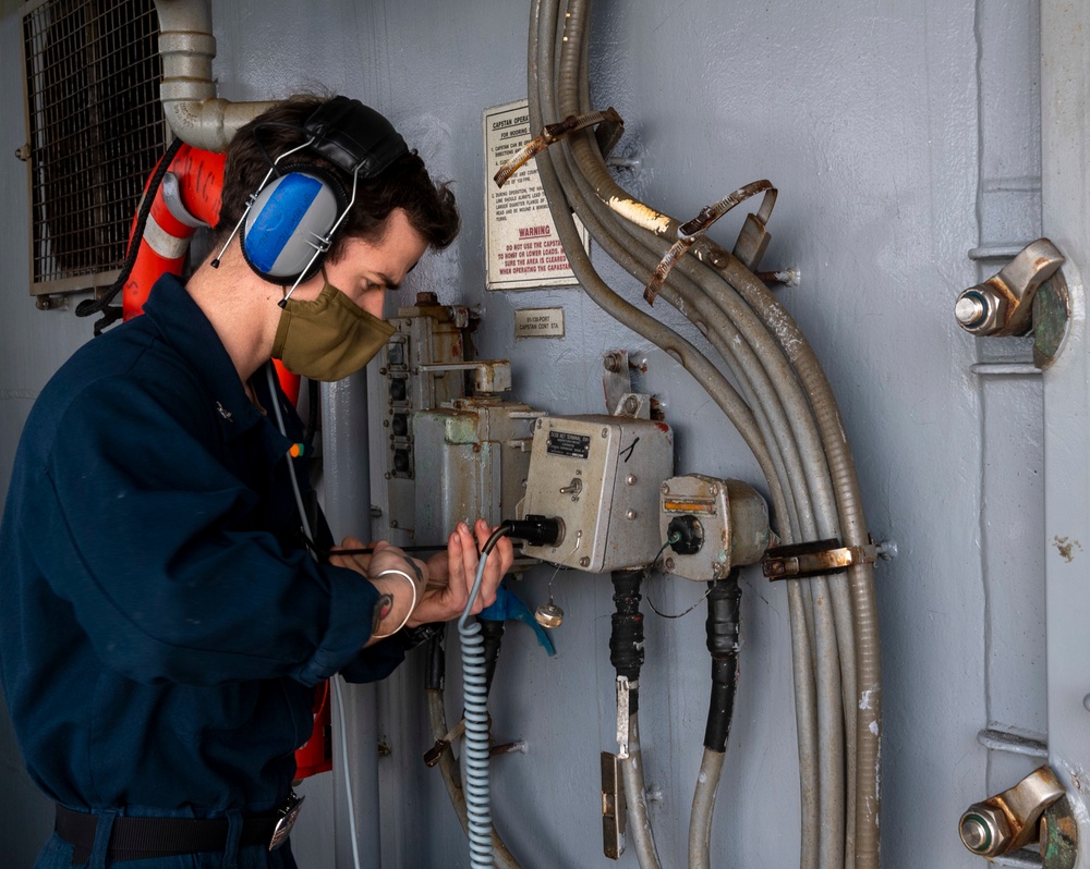 USS America (LHA 6) Sailor troubleshoots a net terminal box.