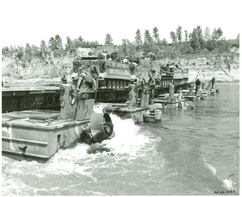 5th Infantry Division M113s crossing mobile bridge with Soldiers maning boat supports.