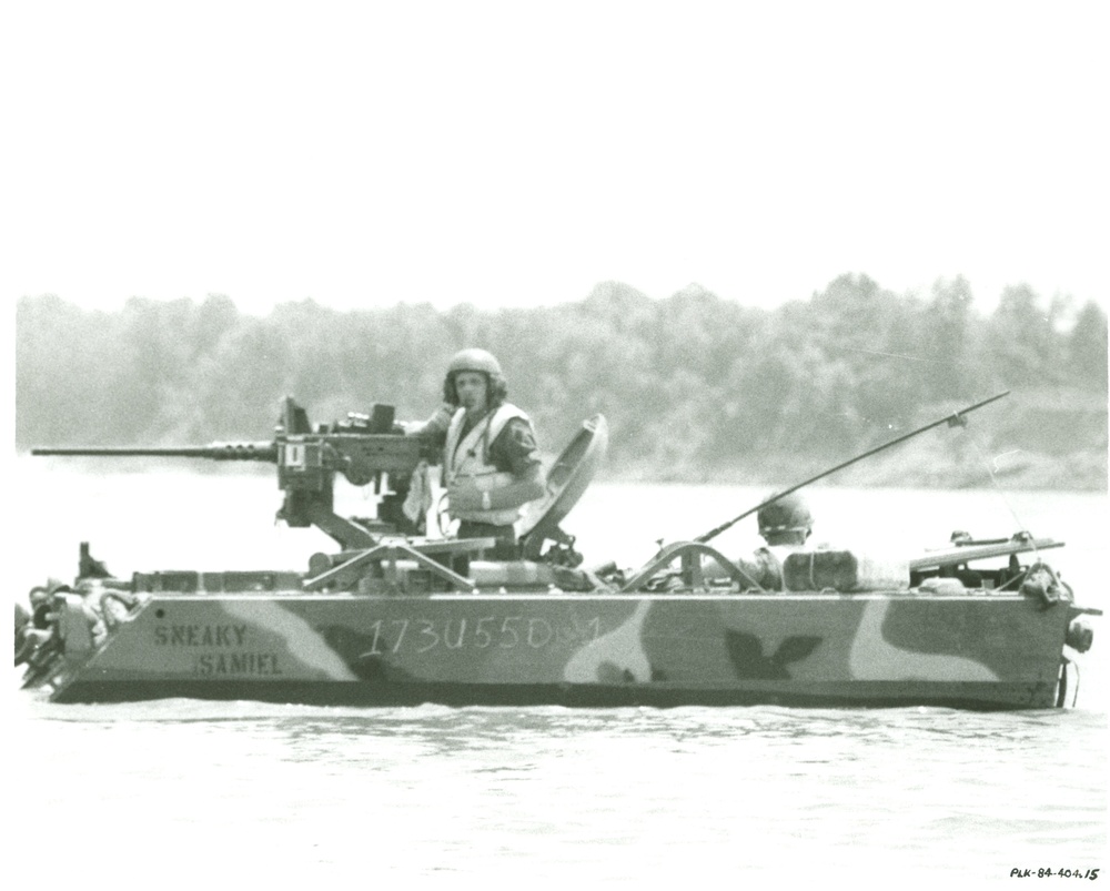 5th Infantry Division gunner perched of M113 in water body at Fort Polk, LA.