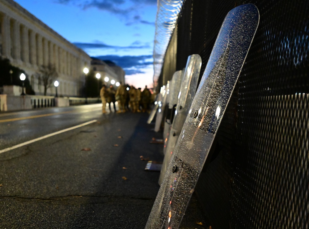 National Guard riot gear leans against Capitol Building perimeter fencing