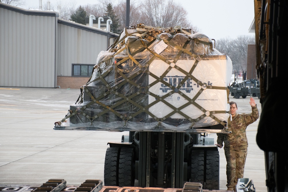 Airmen from the 133rd load duffel bags from the 682nd Engineer Battalion into a C-130 Hercules to Washington D.C.