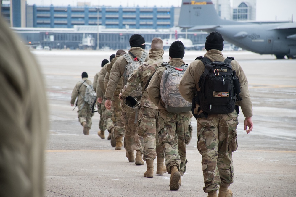Soldiers from the 682nd Engineer Battalion move to board a C-130 Hercules at the 133rd Airlift Wing to Washington D.C.