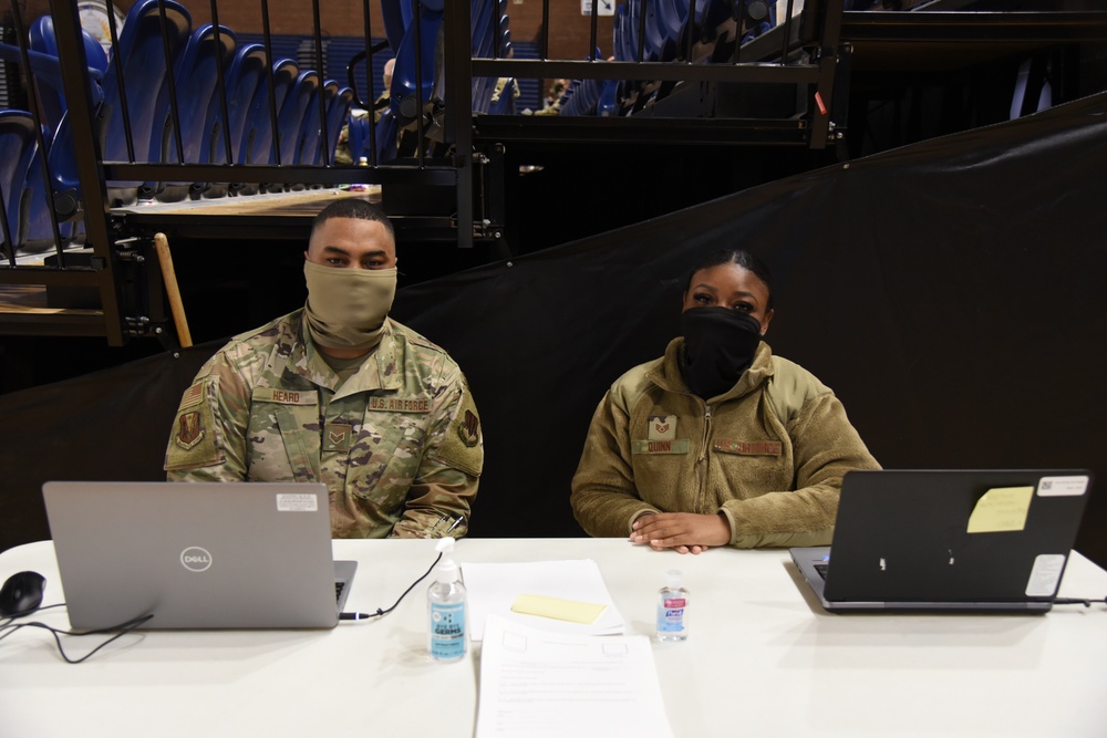 U.S. Air Force Senior Airman Jordan Heard, left, and Staff Sgt. Darian Quinn, both working as in-processors at the District of Columbia armory, pose for a photo in Washington, D.C., Jan. 16, 2021