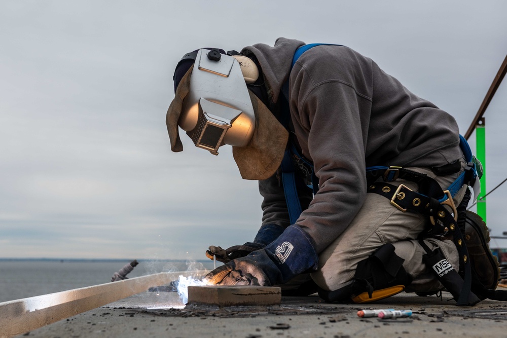 Contractor welds on flight deck aboard USS John C. Stennis (CVN 74)