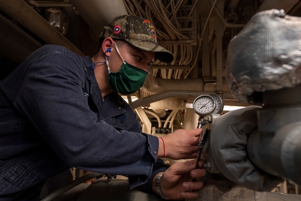 USS America (LHA 6) Sailor holds pressure gauge during drill.