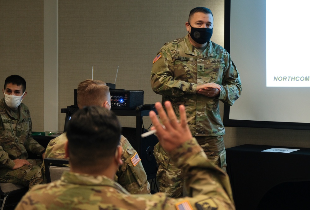 Army and Navy personnel receive command briefings during in-processing for COVID-19 response