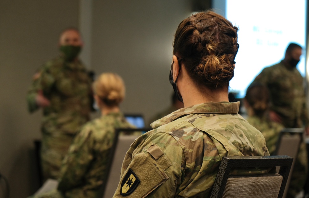 Army and Navy personnel receive command briefings during in-processing for COVID-19 response