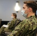 Army and Navy personnel receive command briefings during in-processing for COVID-19 response