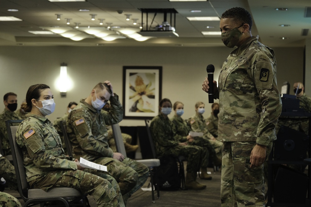 Army and Navy personnel receive command briefings during in-processing for COVID-19 response