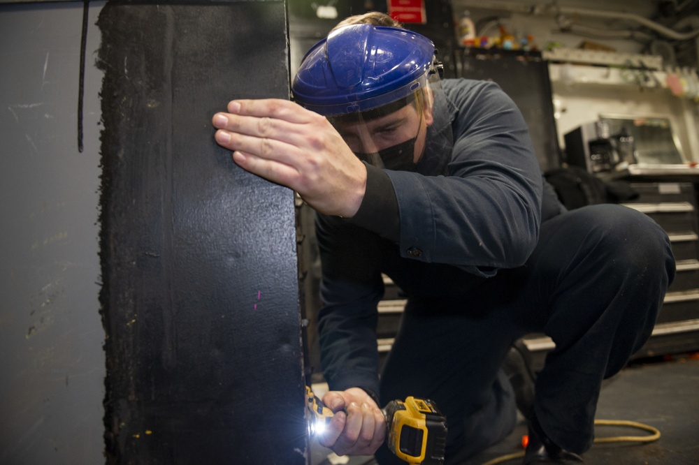 USS Carl Vinson (CVN 70) Sailor Drills Into Tool Locker