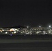 A B-2 Spirit Stealth Bomber takes off silhouetted against Las Vegas city lights