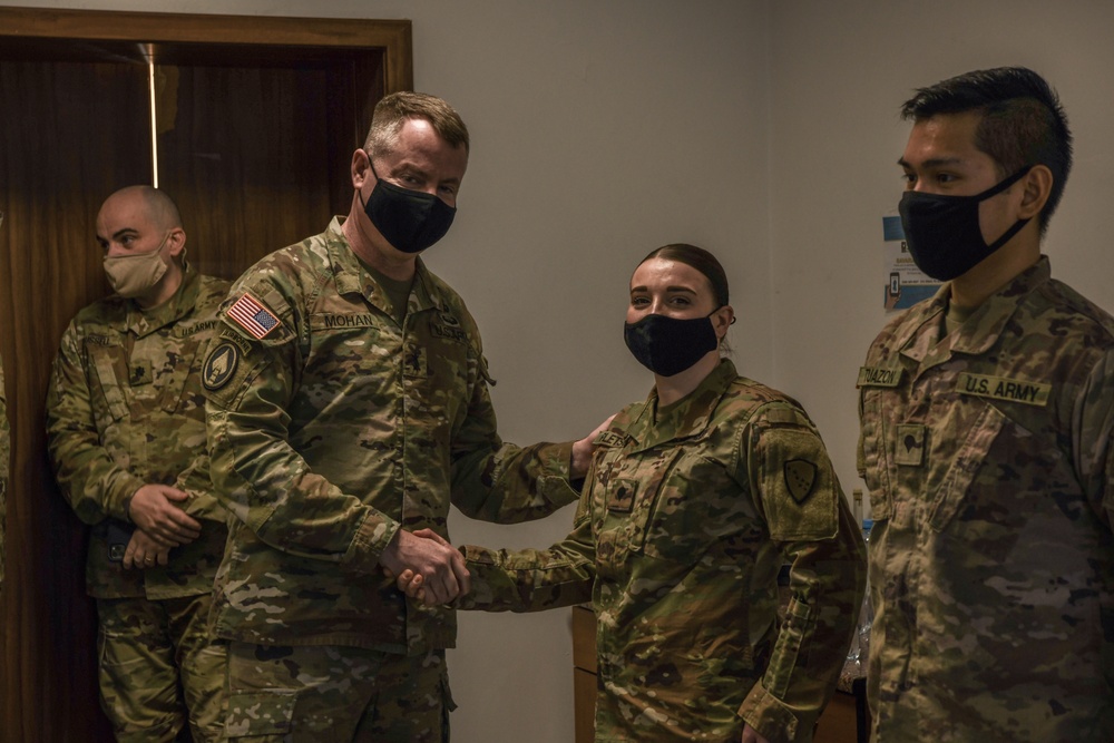 U.S. Army Maj. General Christopher Mohann presents his coin to Alaska Army National Guard Specialist Delaney Pletsch