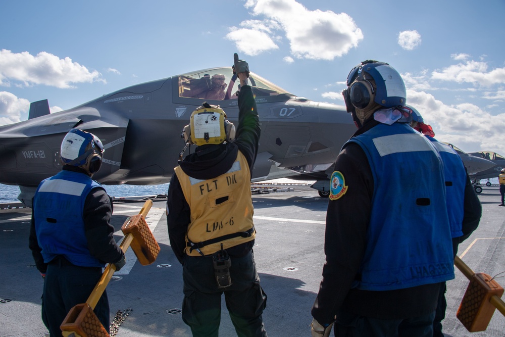 Sailors assigned to the forward-deployed amphibious assault ship USS America (LHA 6) conduct flight operations