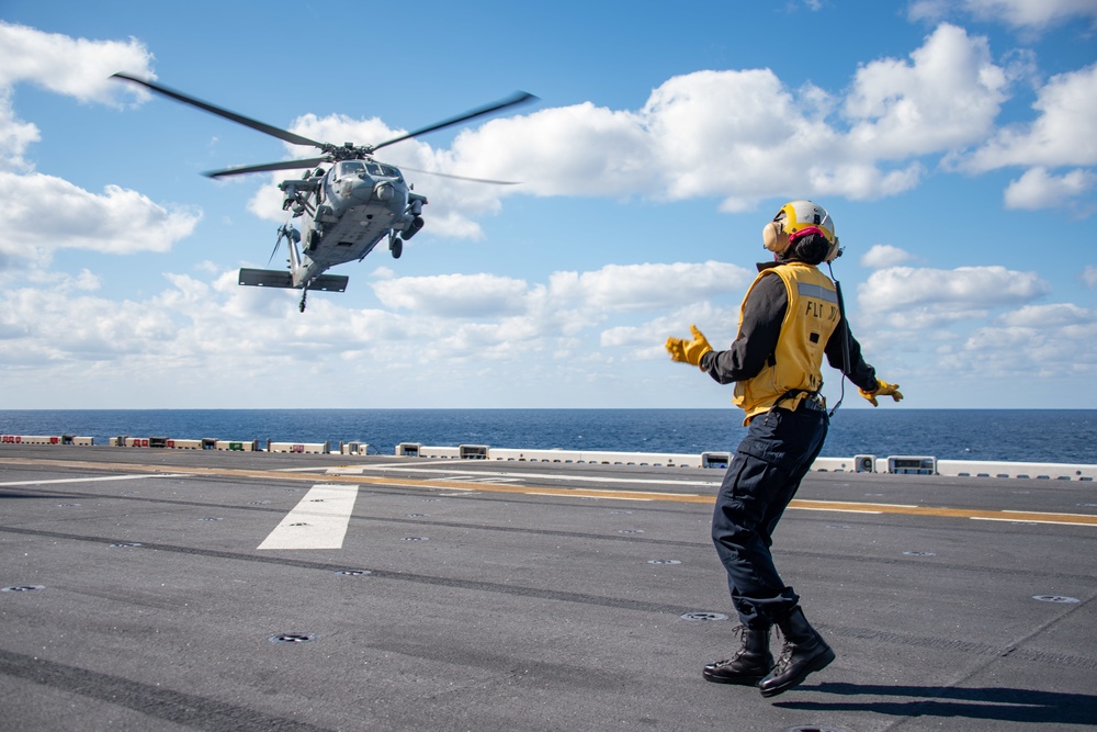 Sailors assigned to the forward-deployed amphibious assault ship USS America (LHA 6) conduct flight operations.
