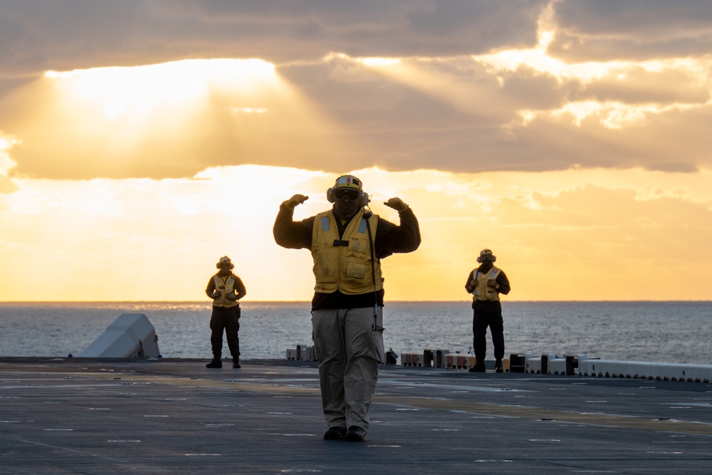 Sailors assigned to the forward-deployed amphibious assault ship USS America (LHA 6) conduct flight operations