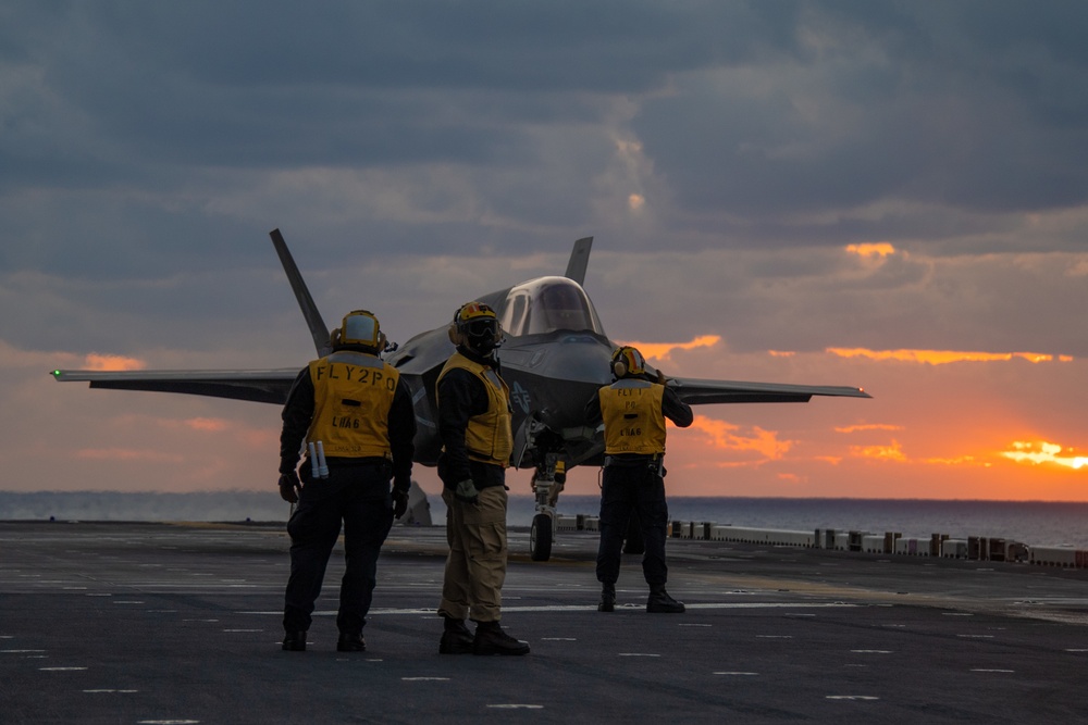 Sailors assigned to the forward-deployed amphibious assault ship USS America (LHA 6) conduct flight operations