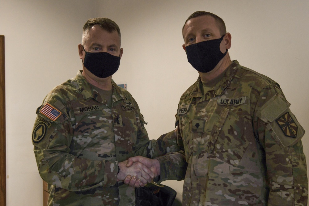 U.S. Army Maj. General Christopher Mohann presents his coin to U.S. Army Specialist Brandon Perry for performing above his grade performing as the Motor Sergeant for the 1225th Combat Sustainment Support Battalion