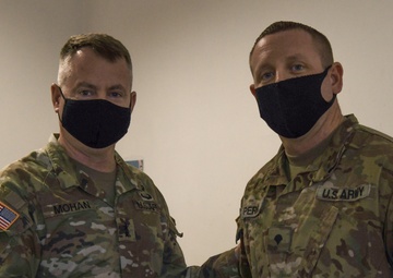 U.S. Army Maj. General Christopher Mohann presents his coin to U.S. Army Specialist Brandon Perry for performing above his grade performing as the Motor Sergeant for the 1225th Combat Sustainment Support Battalion