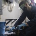 Sailor conducts routine maintenance on a fire hose.